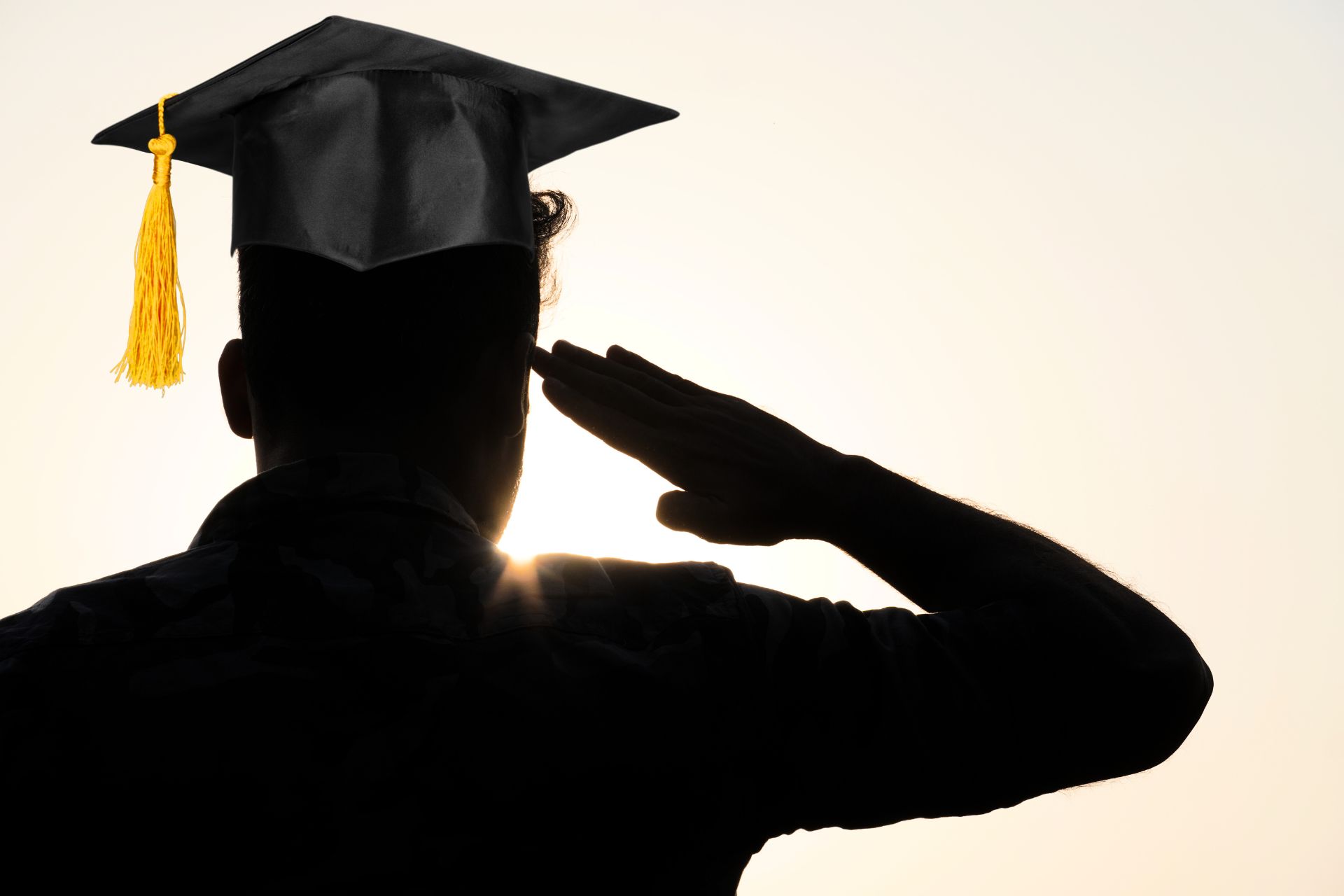 vojnik koji je okrenut leđima i na glavi ima kapicu za promociju nakon diplome